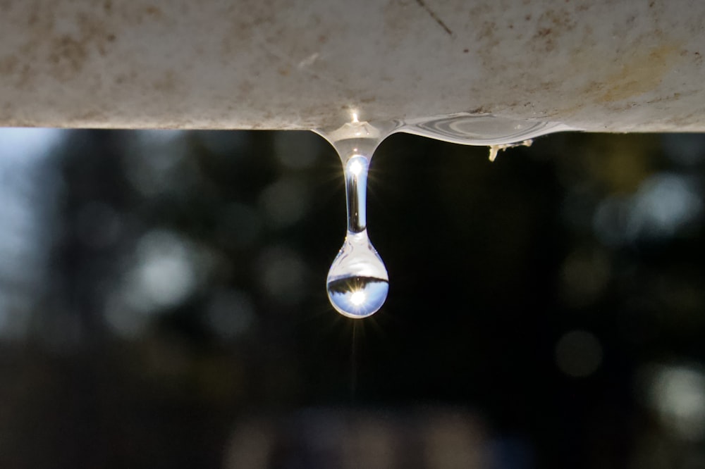 a drop of water hanging from a faucet
