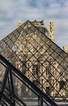 a large glass pyramid with a clock on top of it