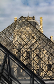 a large glass pyramid with a clock on top of it