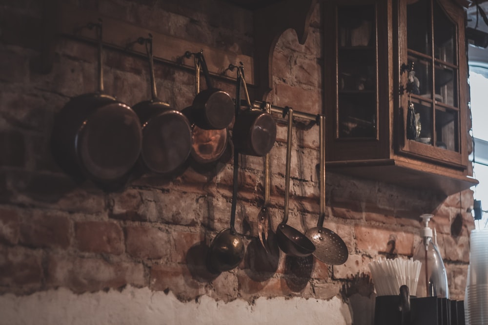 a brick wall with pots and pans hanging on it