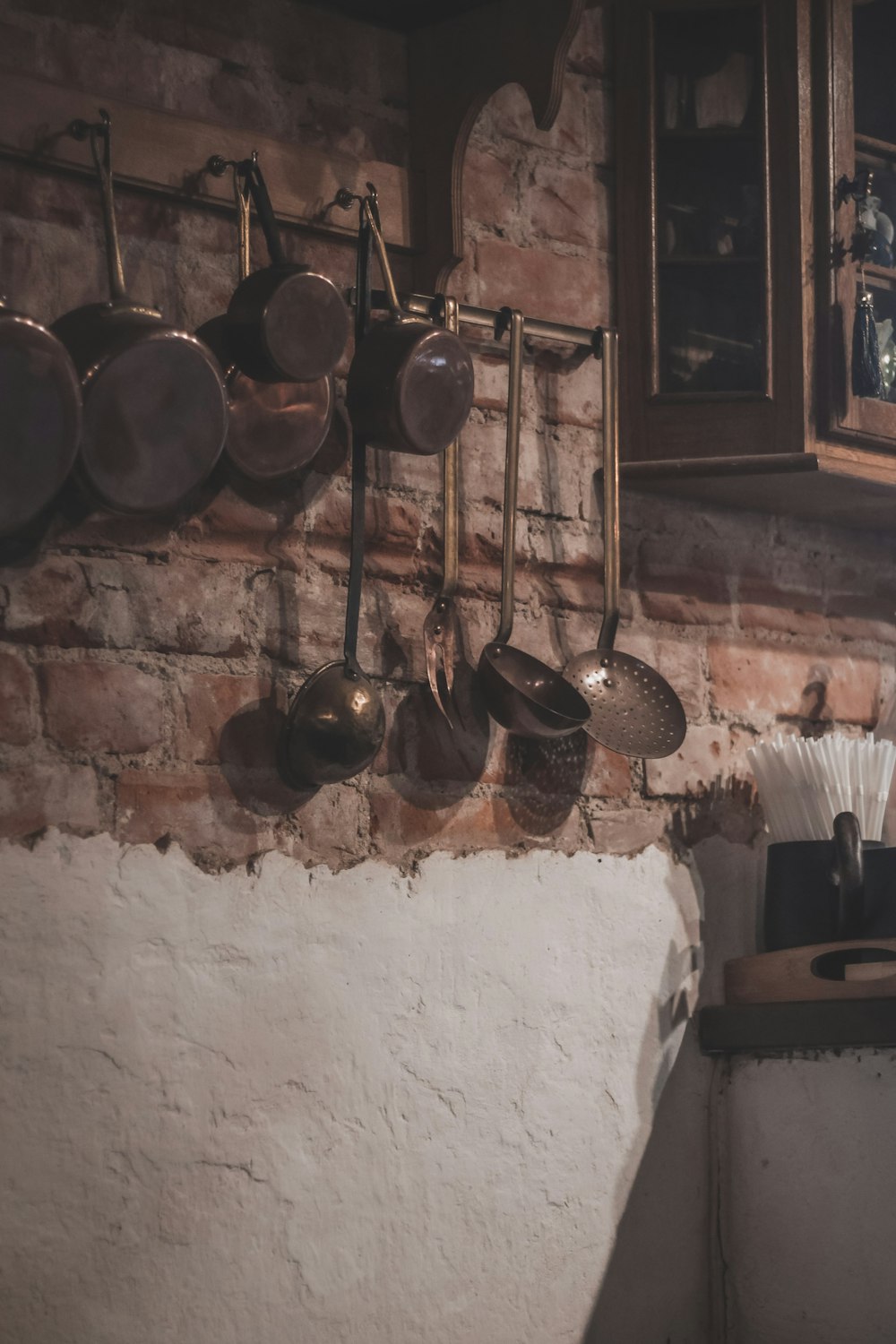 a brick wall with pots and pans hanging on it