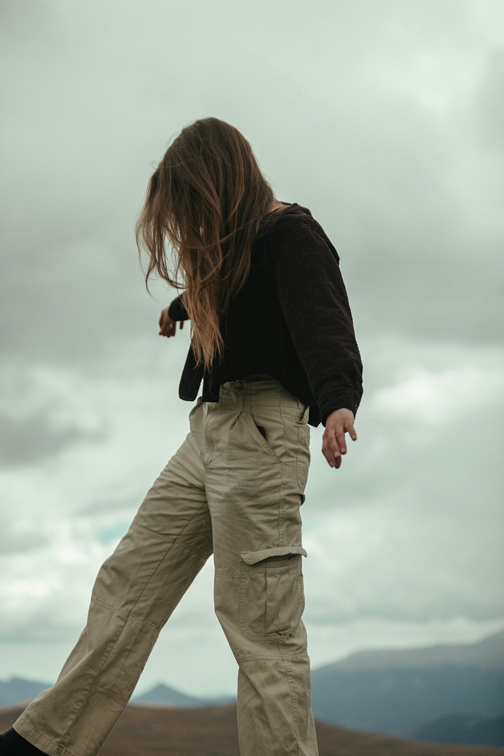 a woman standing on top of a hill