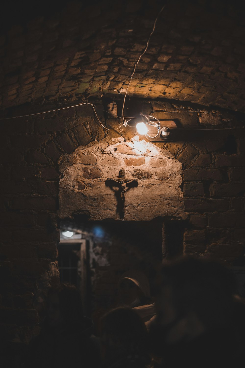 a crucifix hanging from a brick wall