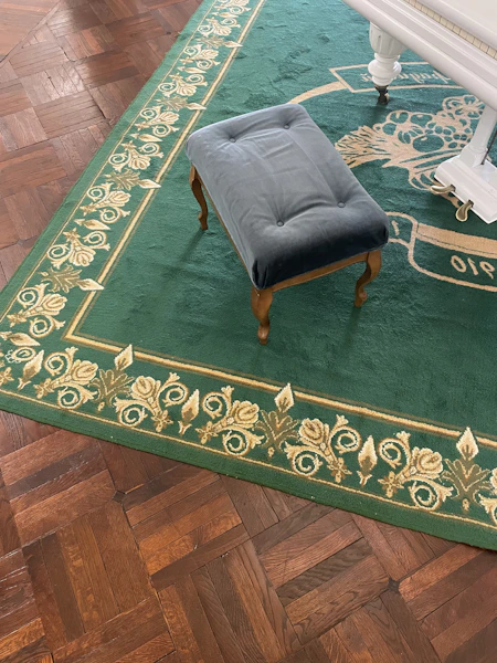 Dark walnut stool next to sage sofa