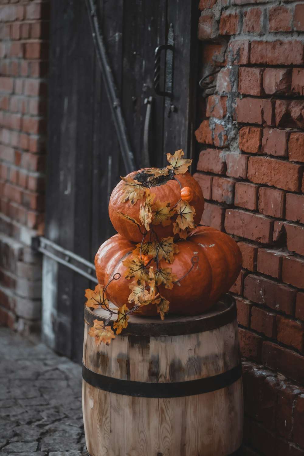 a wooden barrel with pumpkins on top of it