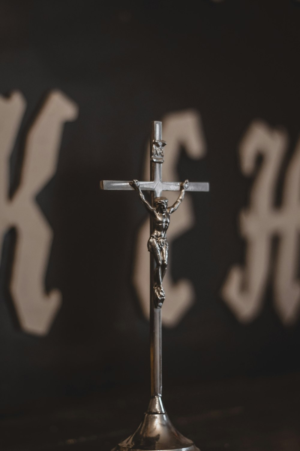 a crucifix on a table in front of a wall