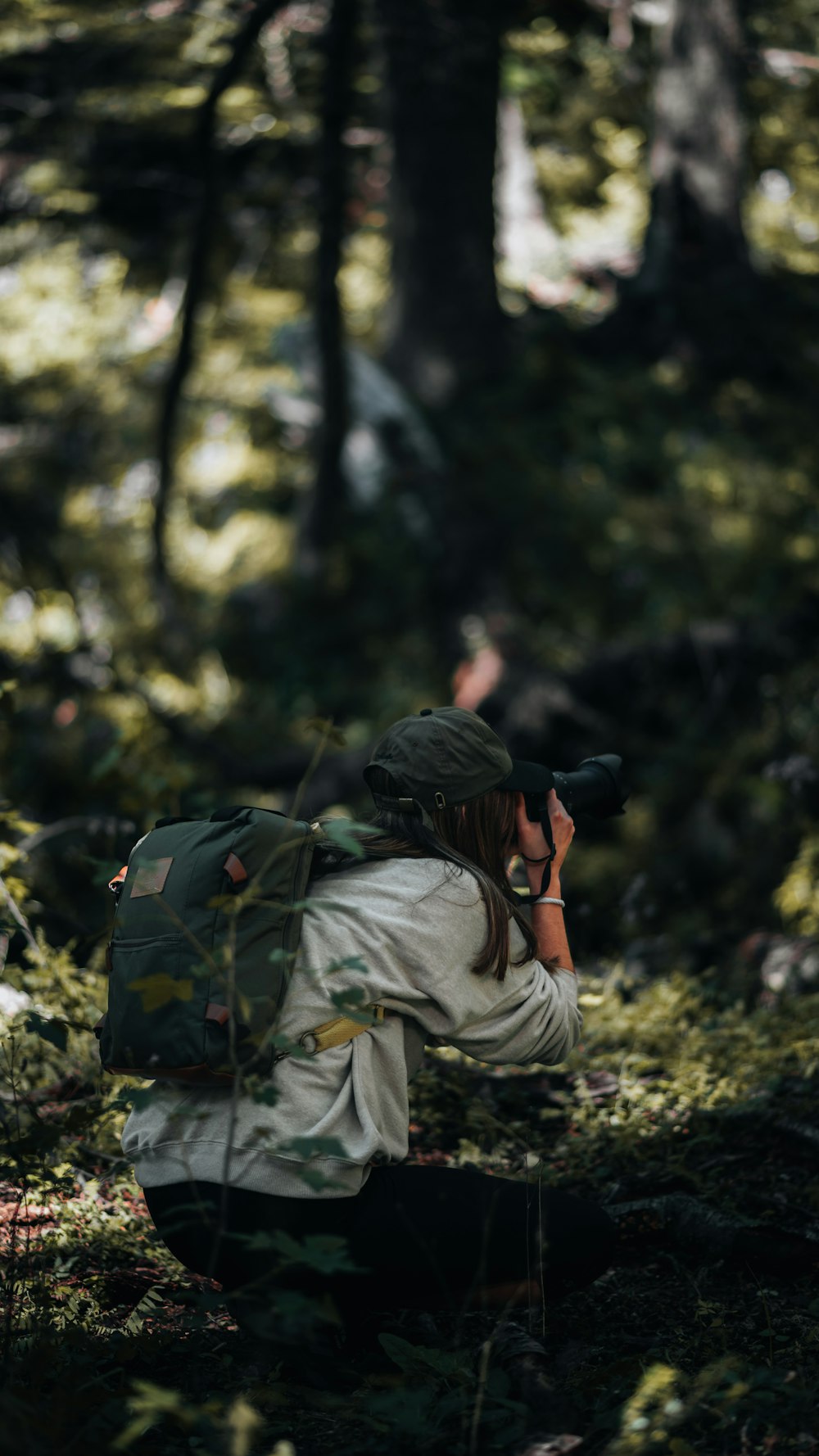 a person with a backpack and a camera in the woods
