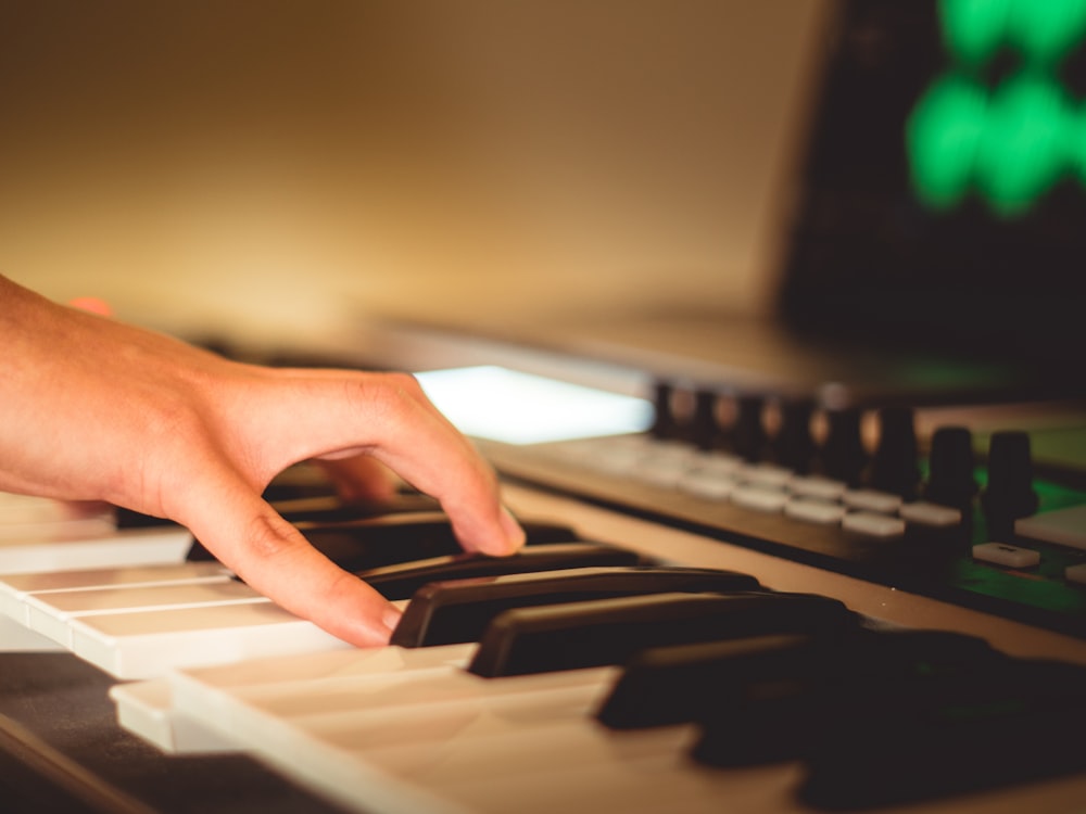 a person's hand on a piano keyboard