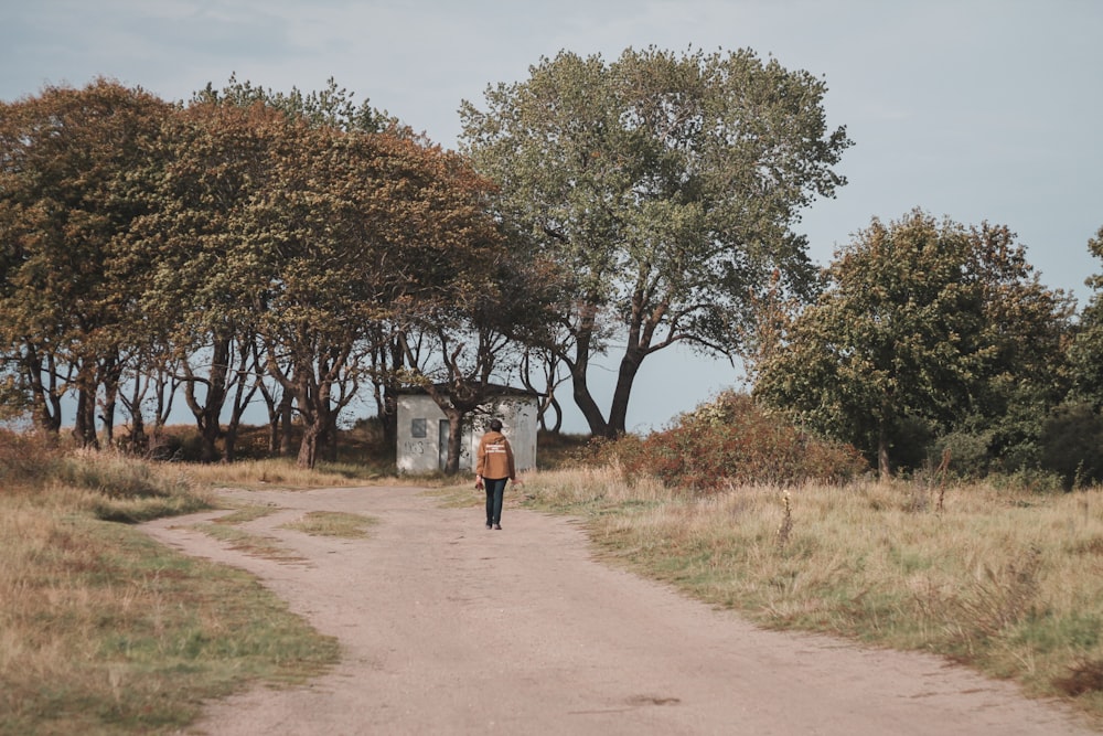 a person is walking down a dirt road