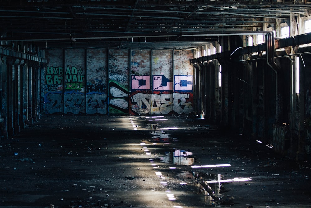 Une pièce sombre avec des graffitis partout sur les murs