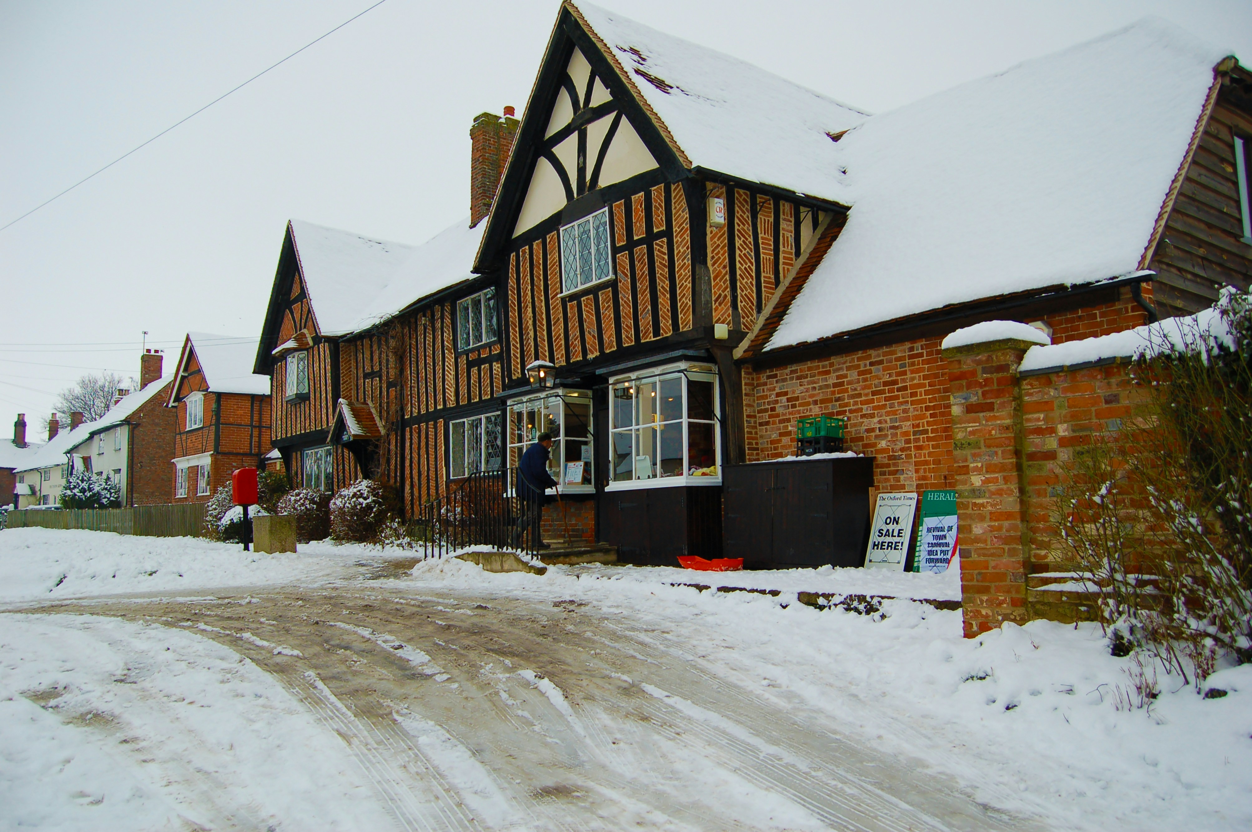 a snow covered street in front of a house