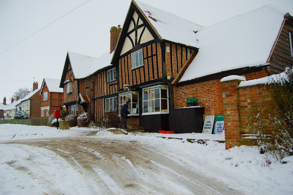 a snow covered street in front of a house