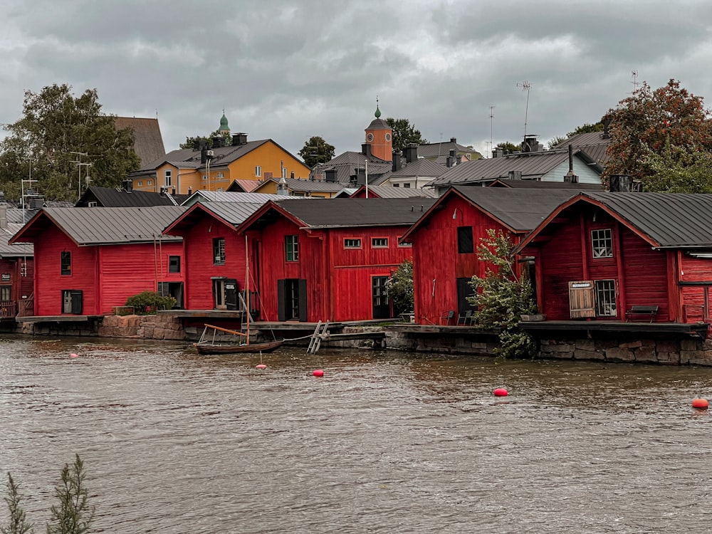 a row of red houses sitting next to a body of water