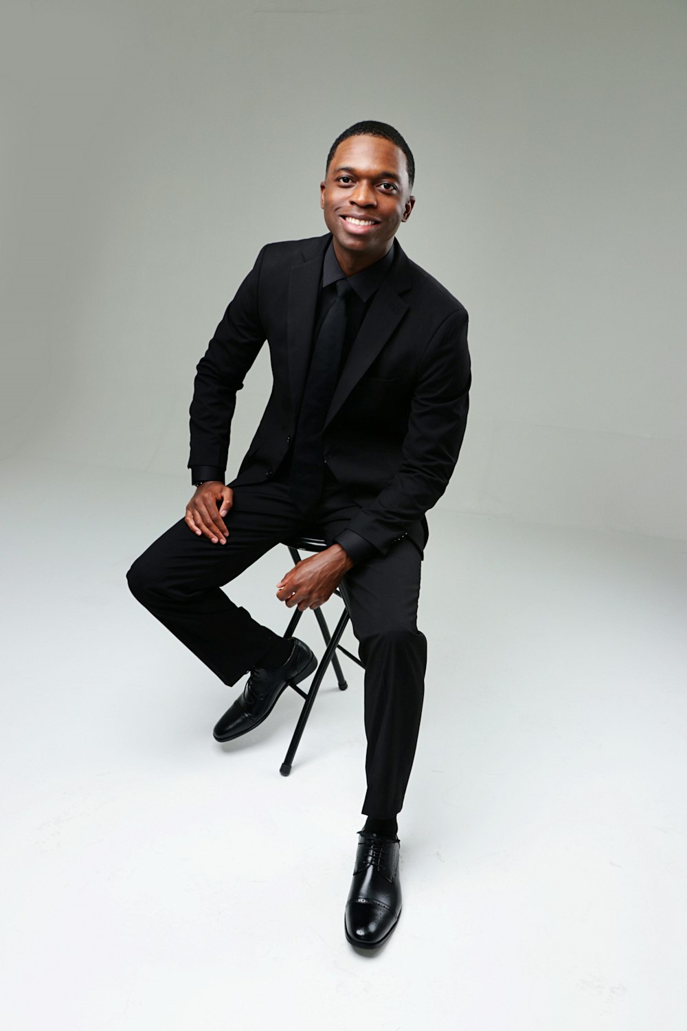 a man in a suit sitting on a chair