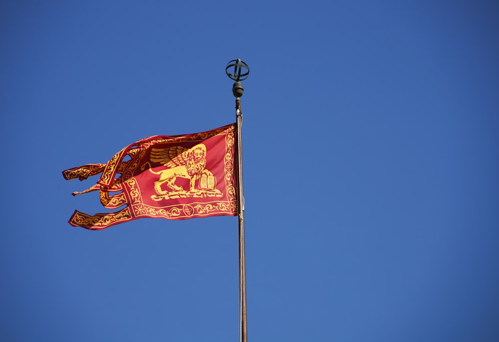 a red and gold flag flying in the wind