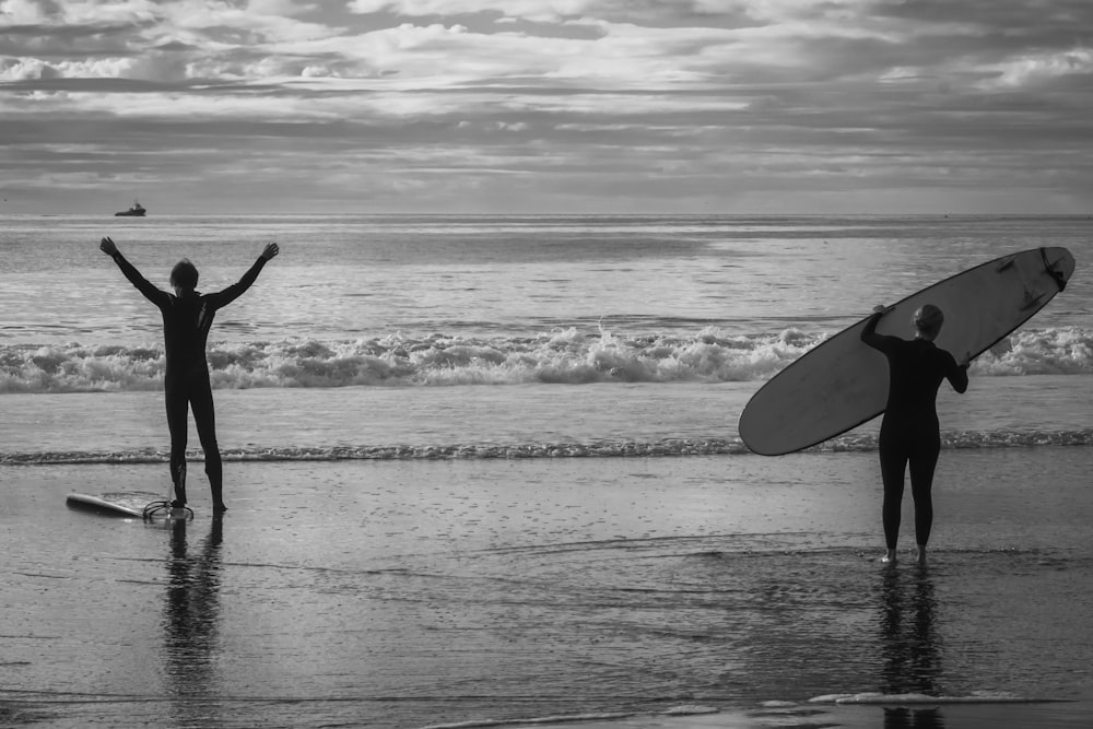 a couple of people standing on top of a beach