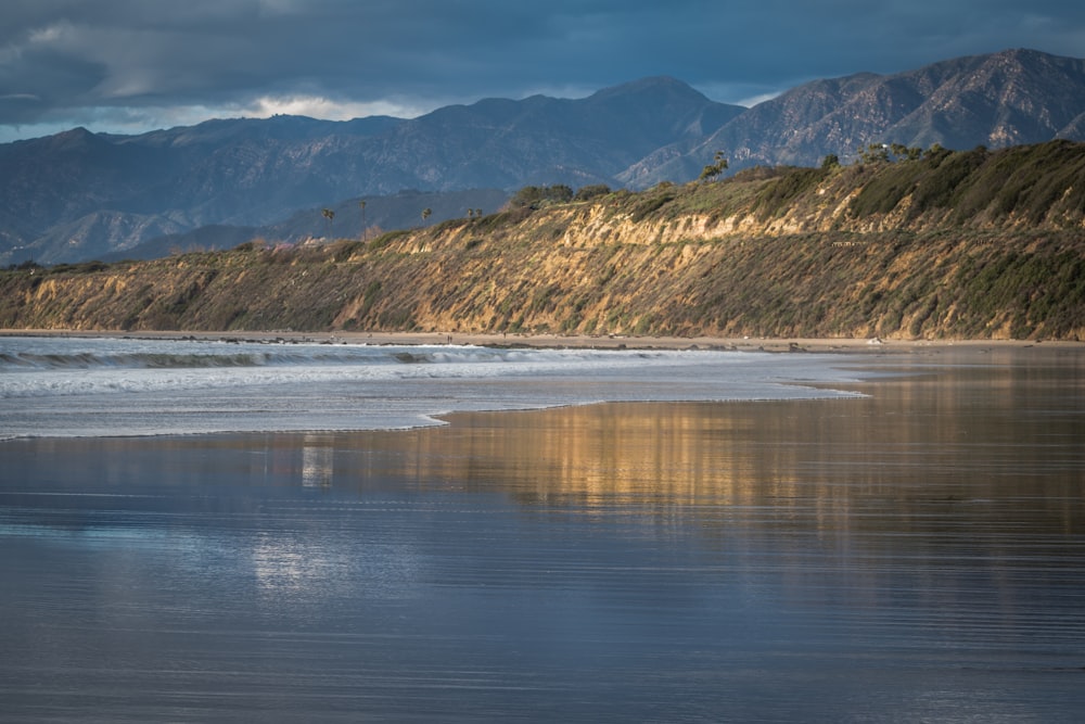 a large body of water with mountains in the background