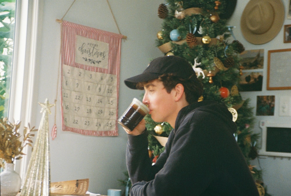 a person sitting at a table drinking a cup of coffee