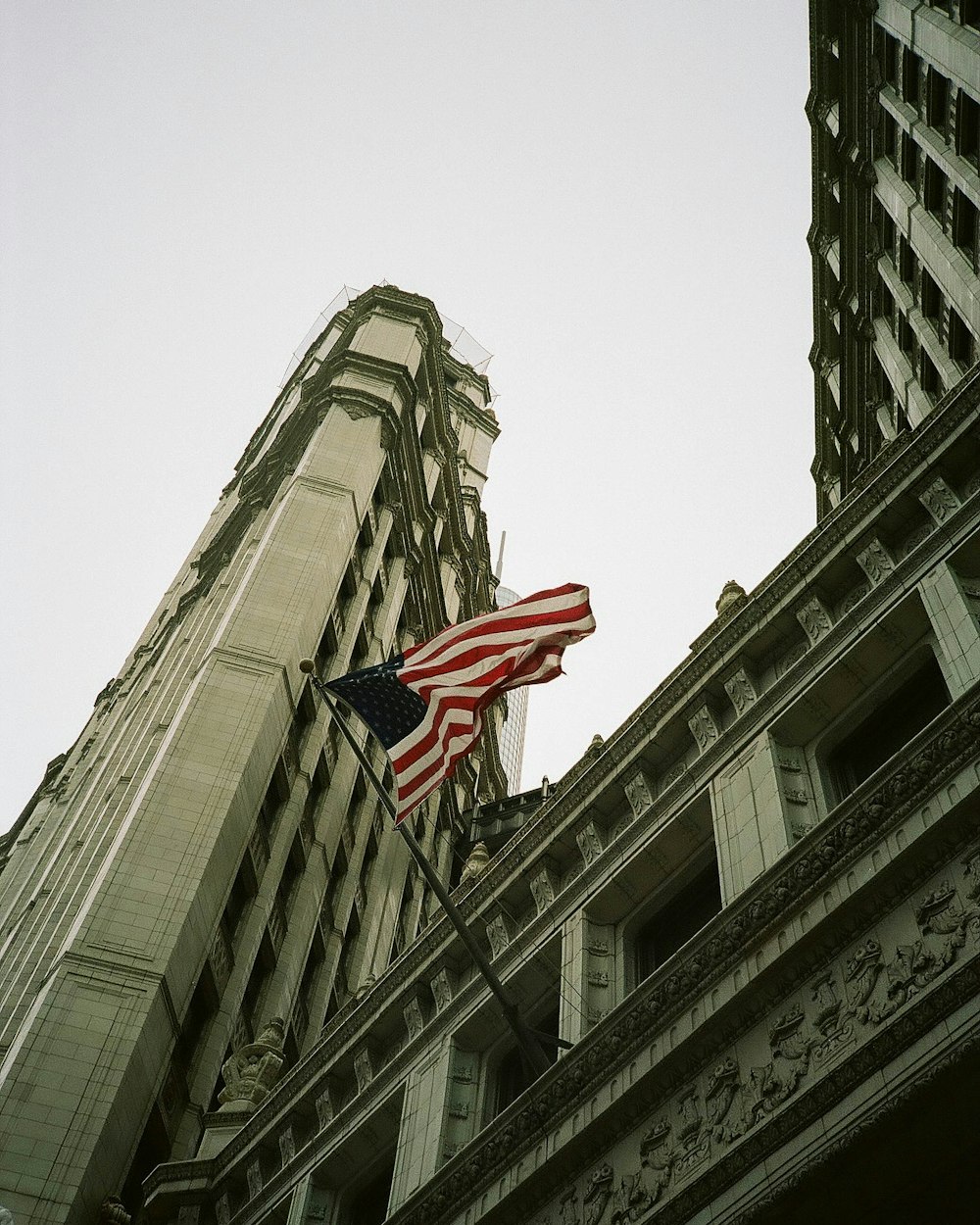 an american flag flying in front of a tall building