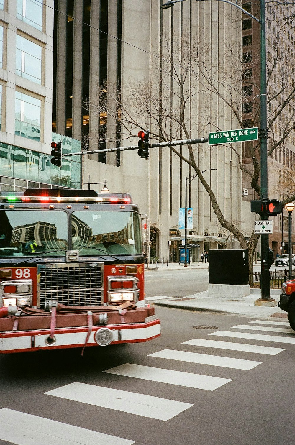 a fire truck driving down a street next to a tall building