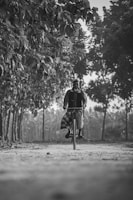 a man riding a bike down a dirt road