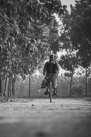 a man riding a bike down a dirt road