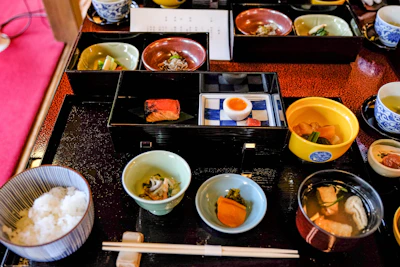 An elegant wooden tray featuring the Tokyo Festival Box with colorful sushi pieces and fresh ginger.