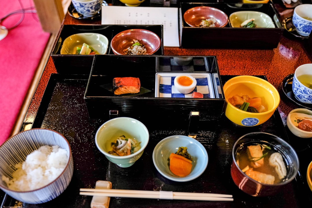 a table topped with bowls of food and chopsticks,