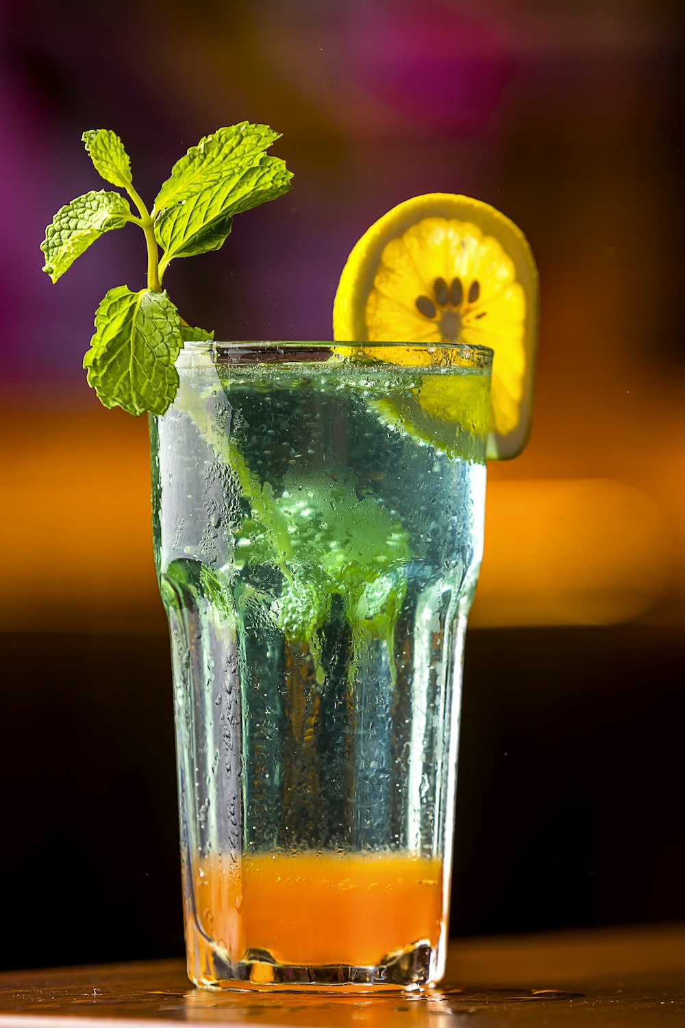 a glass of water with a lemon and mint garnish