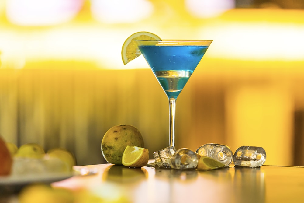 a blue martini with a lime wedge on the rim