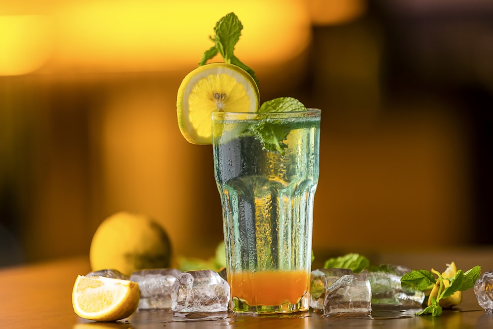 a glass of water with a lemon and mint garnish