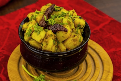 a bowl of food sitting on top of a wooden plate