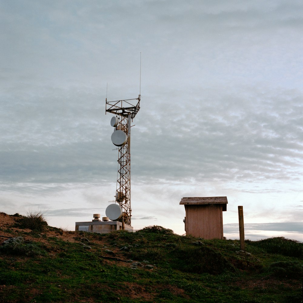 a cell tower on a hill with a sky background