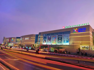 A vibrant LED signboard glowing outside a busy retail store at dusk.