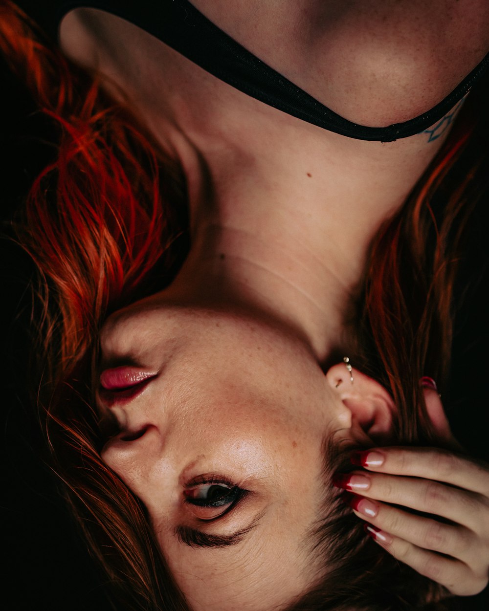 a woman with red hair is laying down