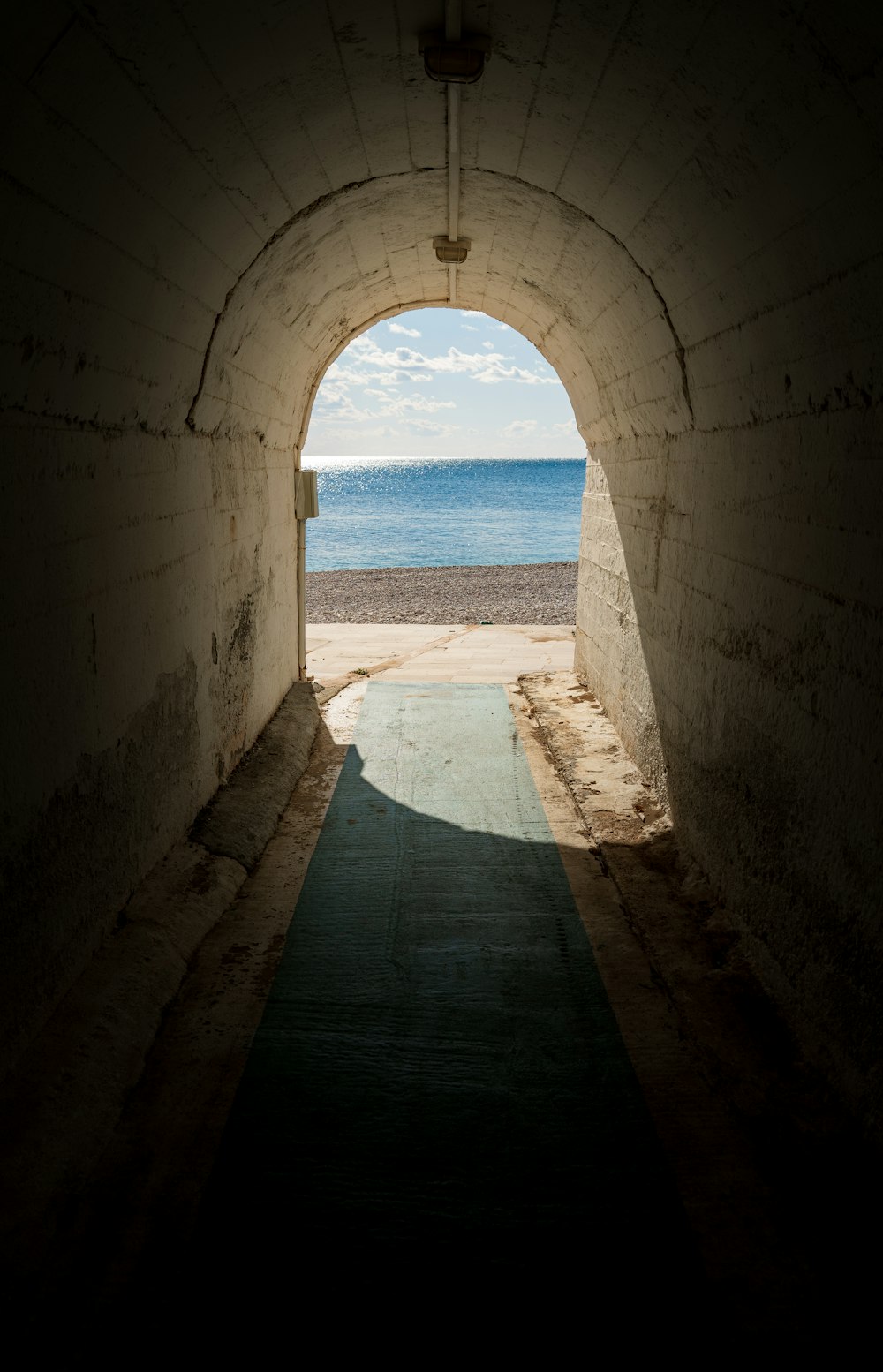 Ein Tunnel, der zu einem Strand mit Blick auf das Meer führt