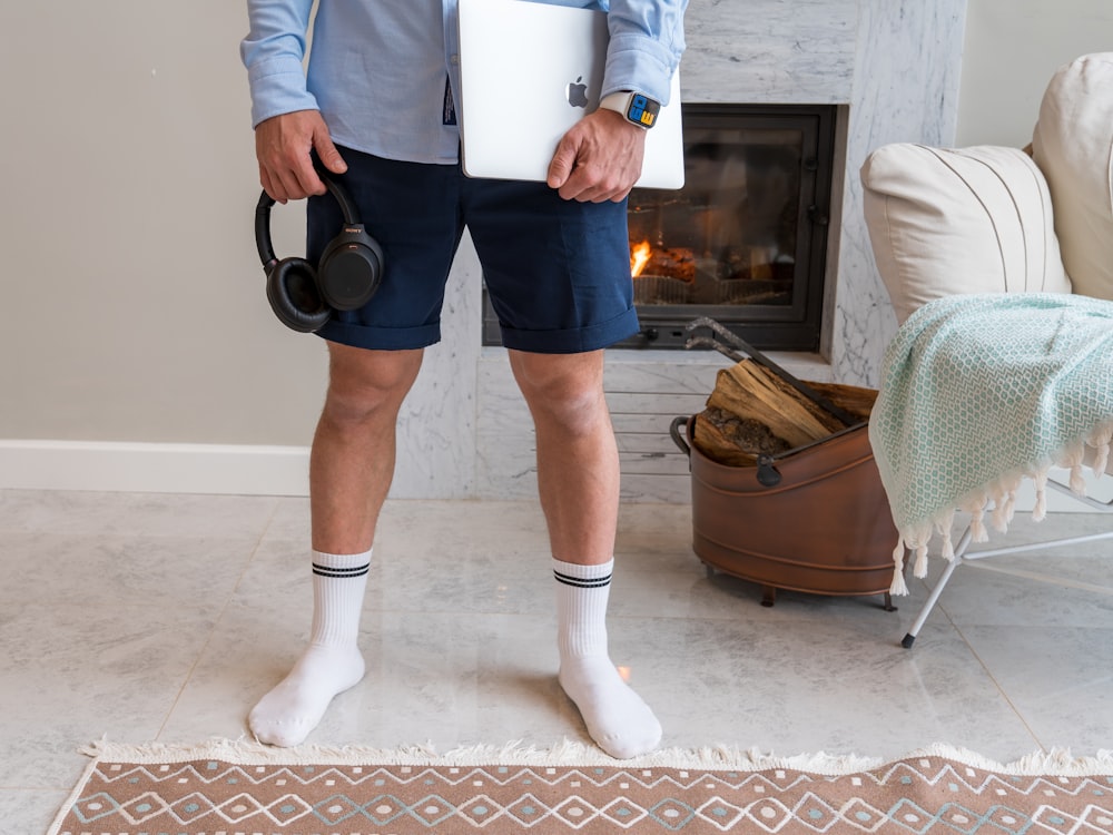 a man standing in front of a fireplace holding a camera