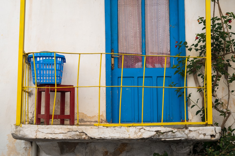 a balcony with two chairs and a blue door