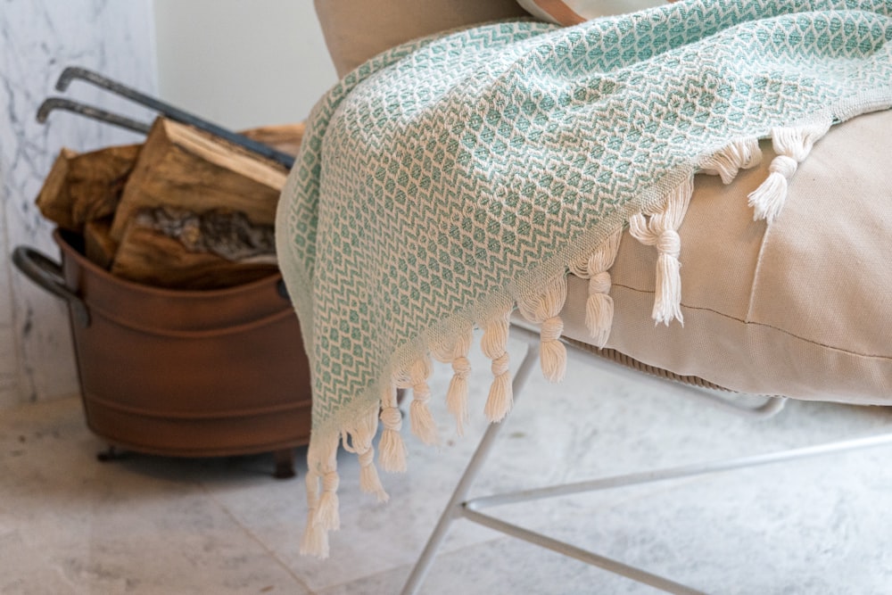 a blanket on a chair with a suitcase in the background