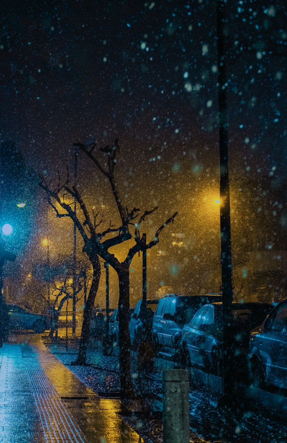 a city street at night during a snow storm