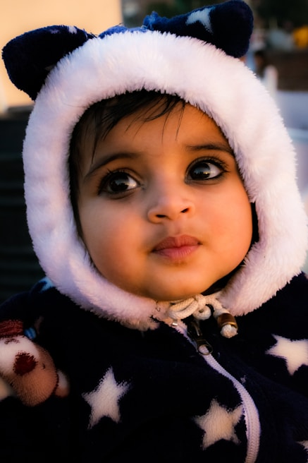 A young child wearing a minimalist, solid color hoodie with clean lines and no visible branding