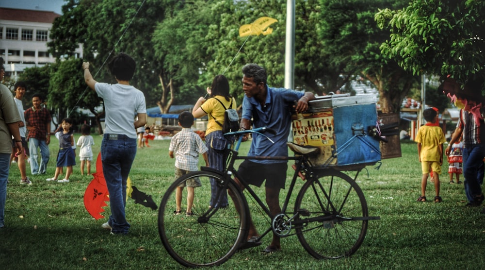 a group of people standing around a man on a bike