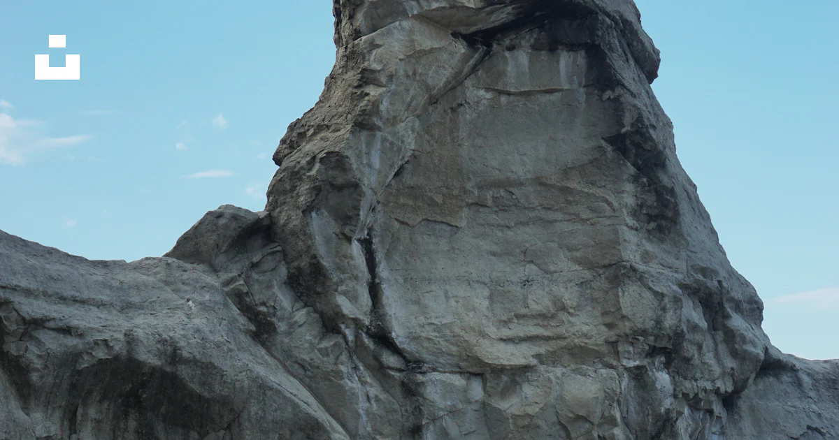 A large rock formation in the middle of a body of water photo – Free ...