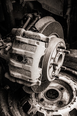 Close-up of used car brake pads stacked neatly on a wooden surface.