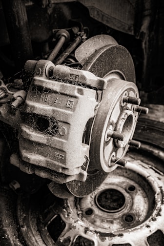 Close-up of used car brake pads stacked neatly on a wooden surface.