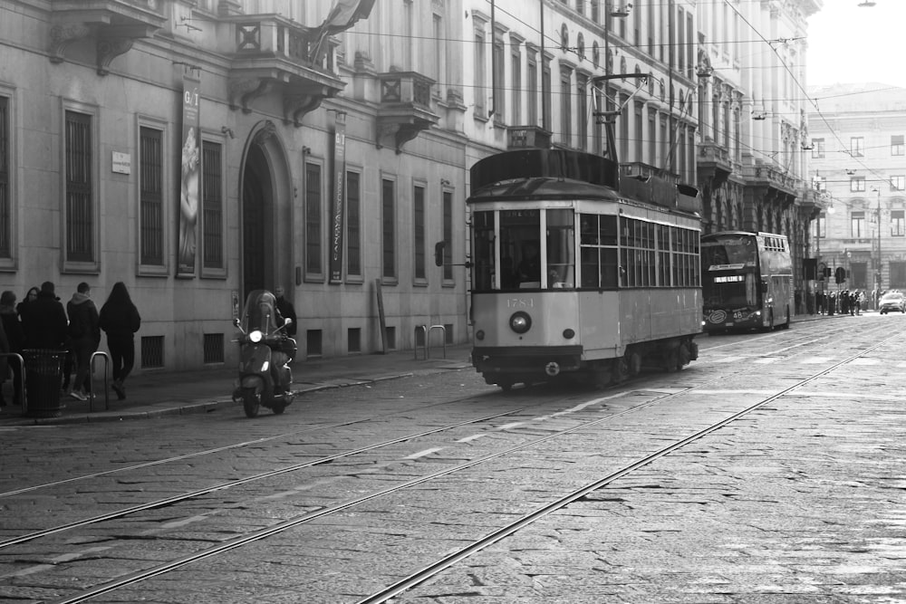 a black and white photo of a trolley on a street