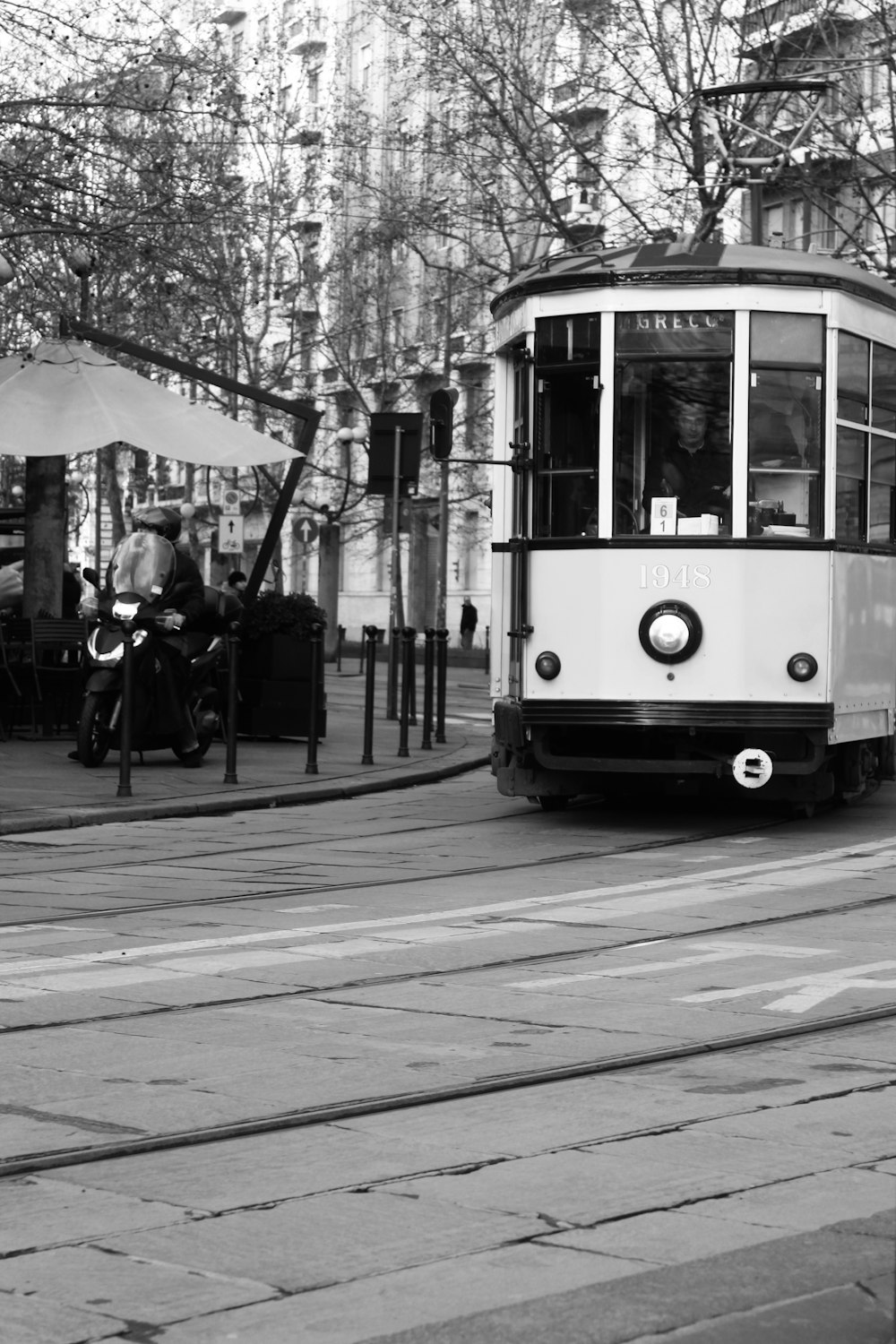 a black and white photo of a trolley on a street