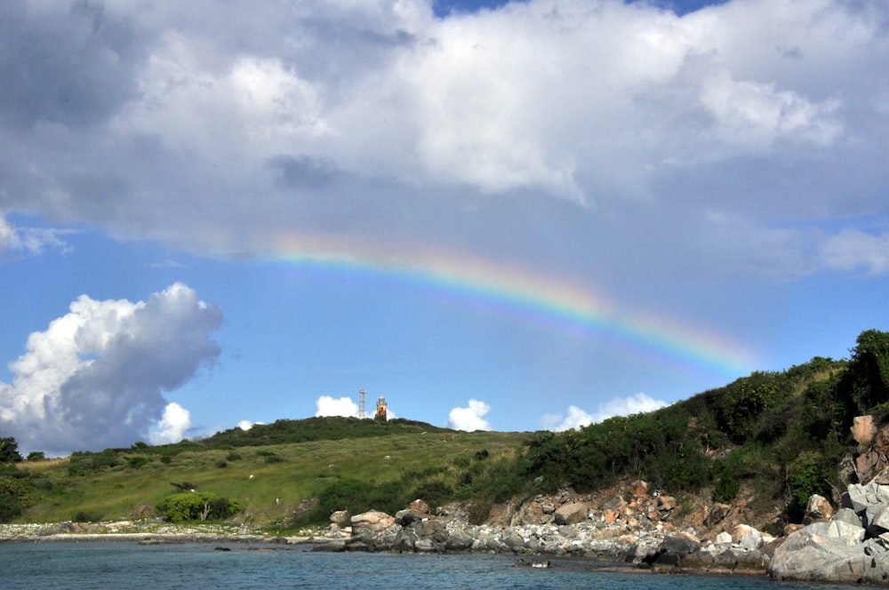 Un arco iris en el cielo sobre un cuerpo de agua