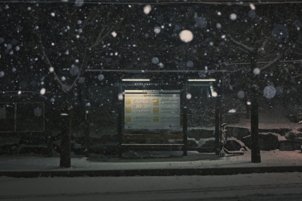 a bus stop covered in snow at night