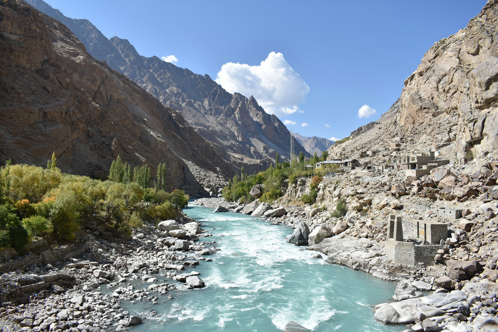 a river running through a rocky valley surrounded by mountains